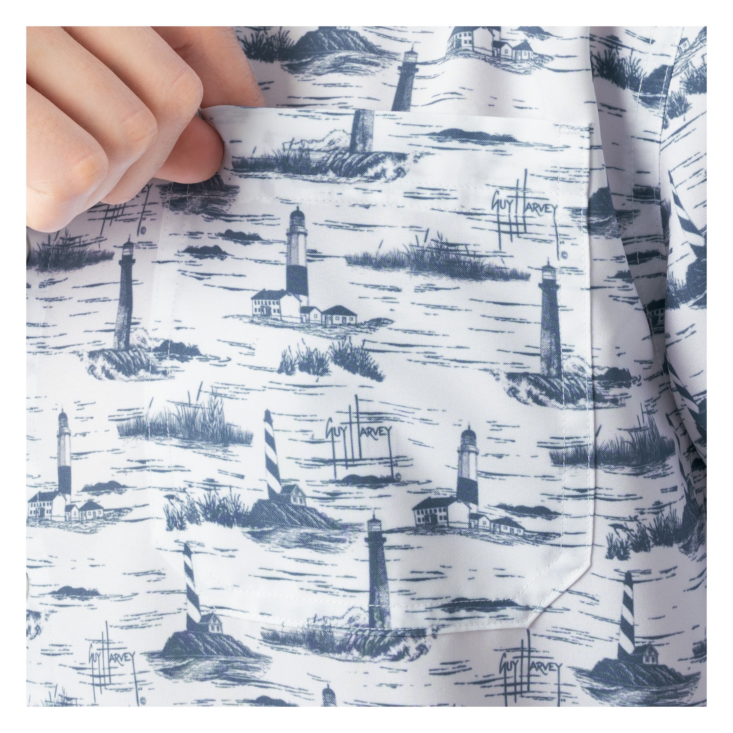 Close-up of left chest pocket with lighthouse pattern, held by a hand.