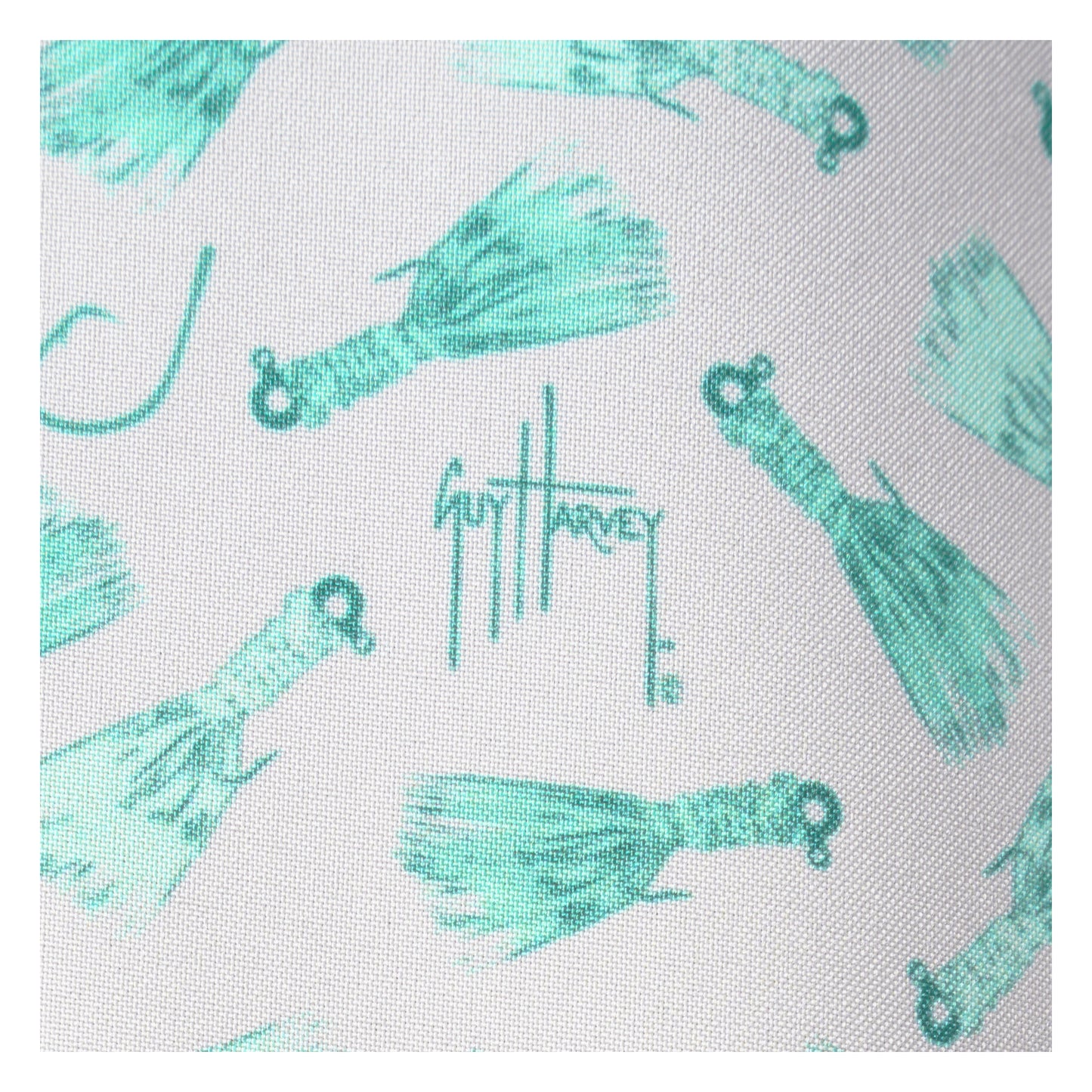 Pattern of turquoise fishing lures with Guy Harvey logo on a white background
