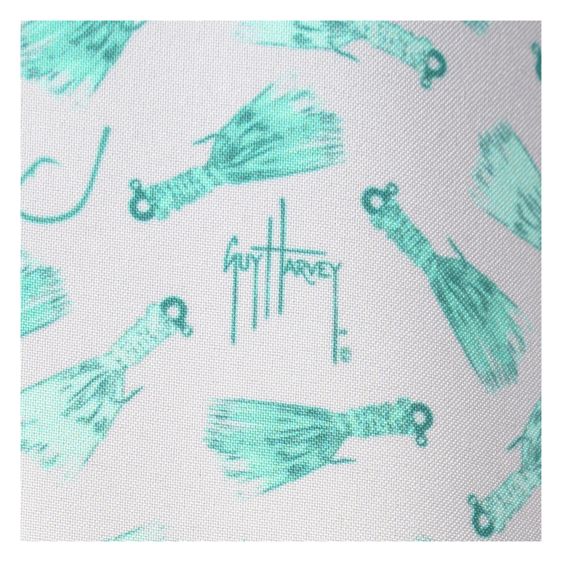 Pattern of turquoise fishing lures with Guy Harvey logo on a white background