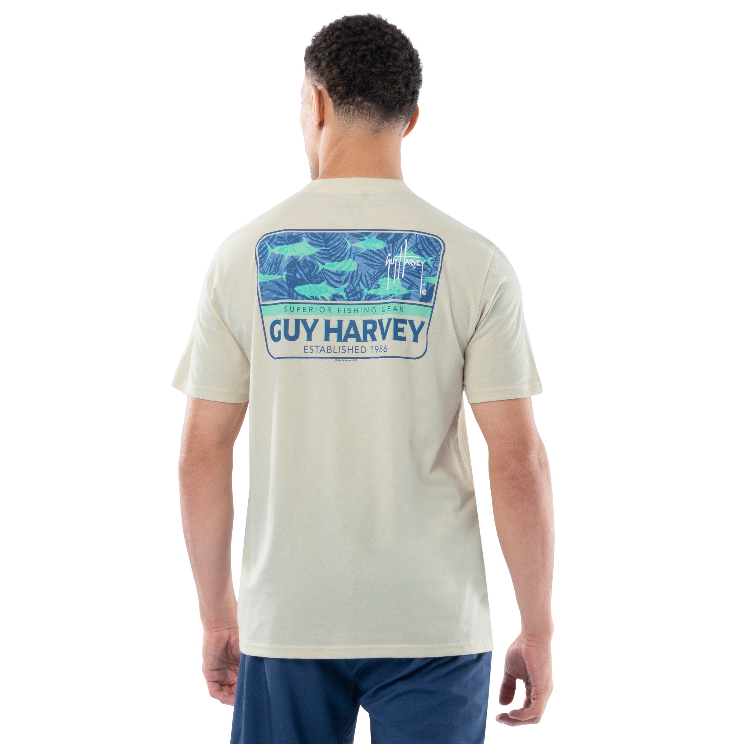 Man wearing a Guy Harvey t-shirt with a fishing graphic on the back against a white background