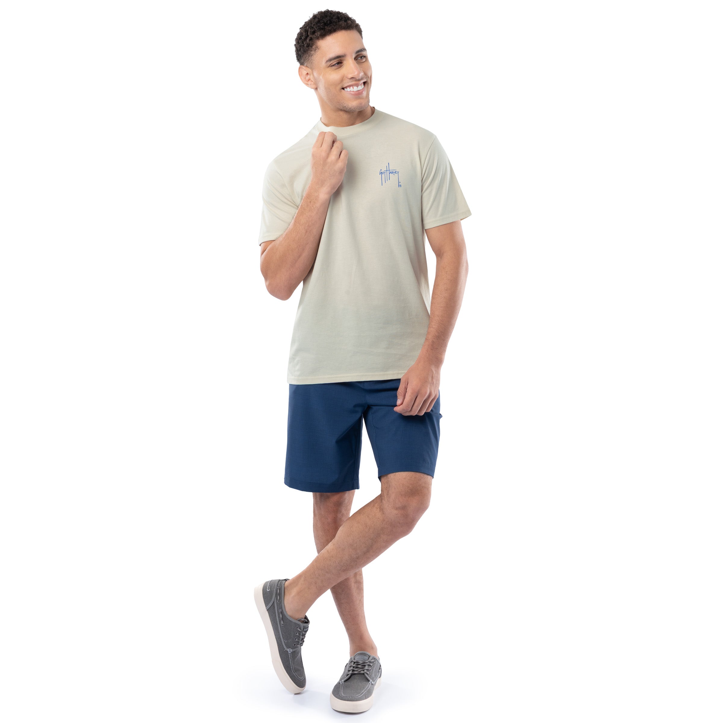 Man wearing a light-colored t-shirt and blue shorts on a white background