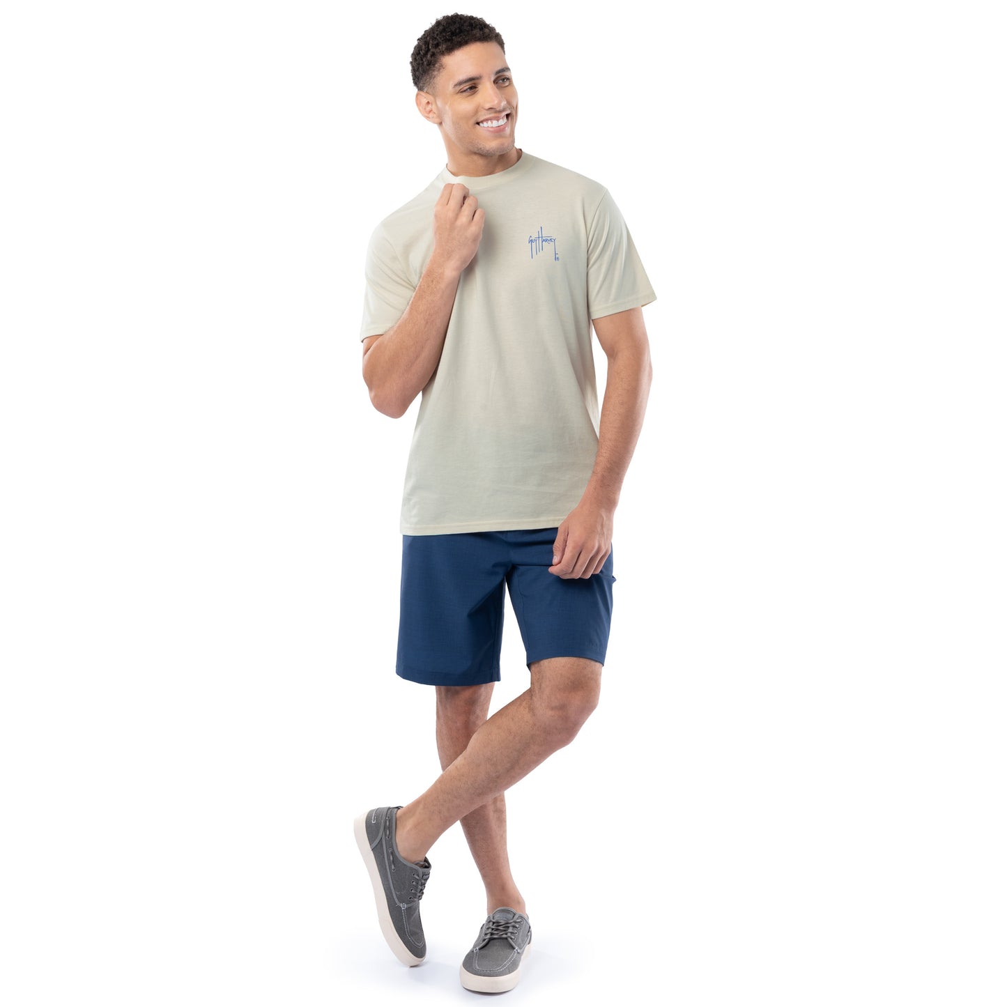 Man wearing a light-colored t-shirt and blue shorts on a white background