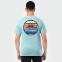 Person wearing a light green Guy Harvey t-shirt with a sailfish graphic on the back against a white background