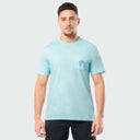 Man wearing a light blue t-shirt with a small logo on a plain background