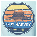 Guy Harvey logo with a fish illustration and sunset design on a light blue background