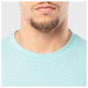 Close-up of a person wearing a light blue shirt with a plain background