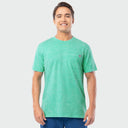 Man wearing a green washed t-shirt with a small logo on a light gray background