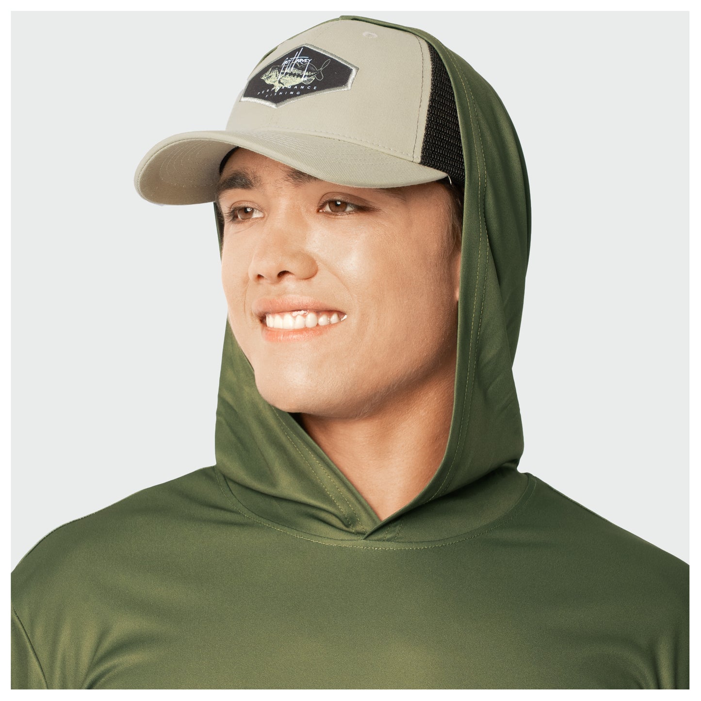 Person wearing a green hooded shirt and beige cap on a white background