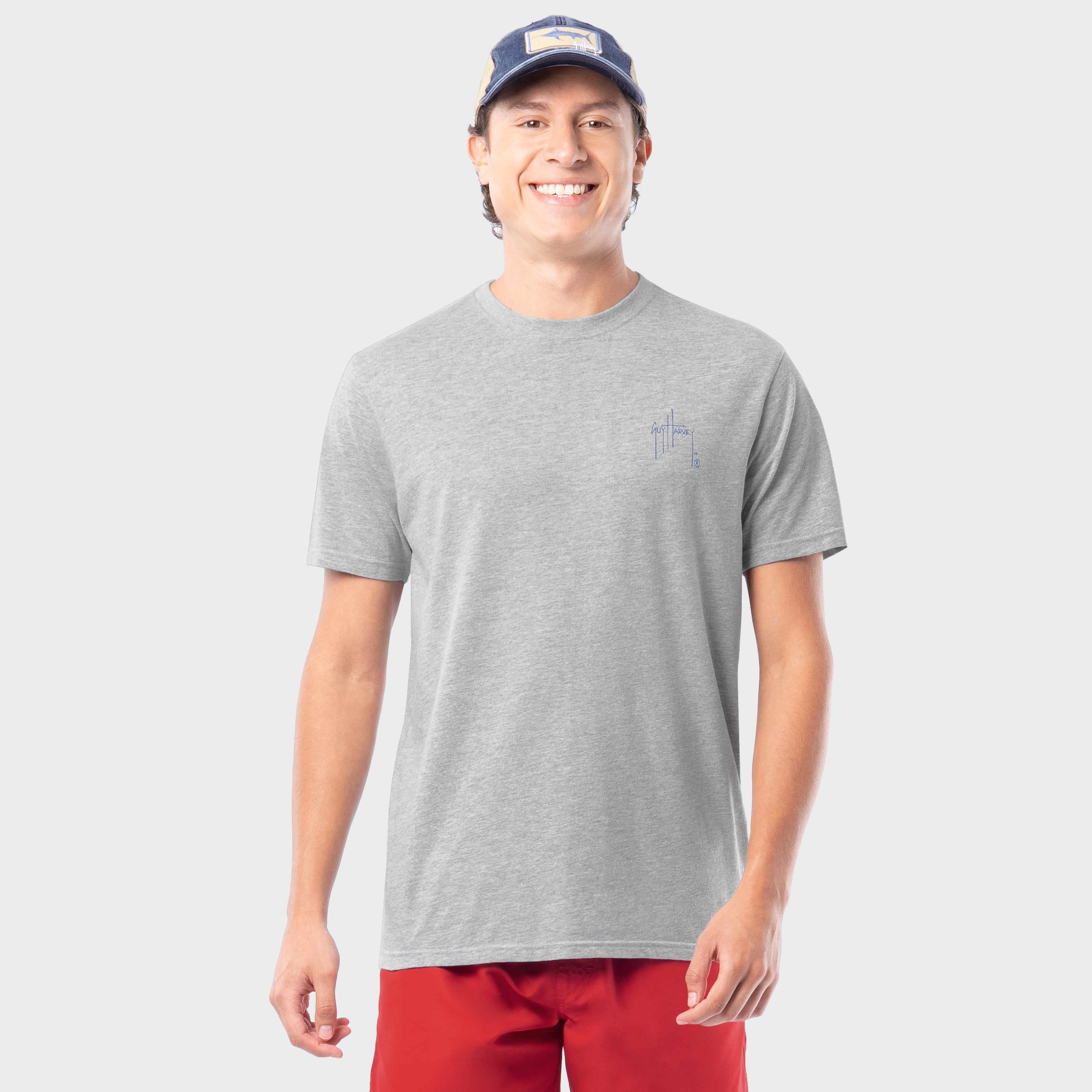 Man wearing a gray t-shirt and red shorts on a white background