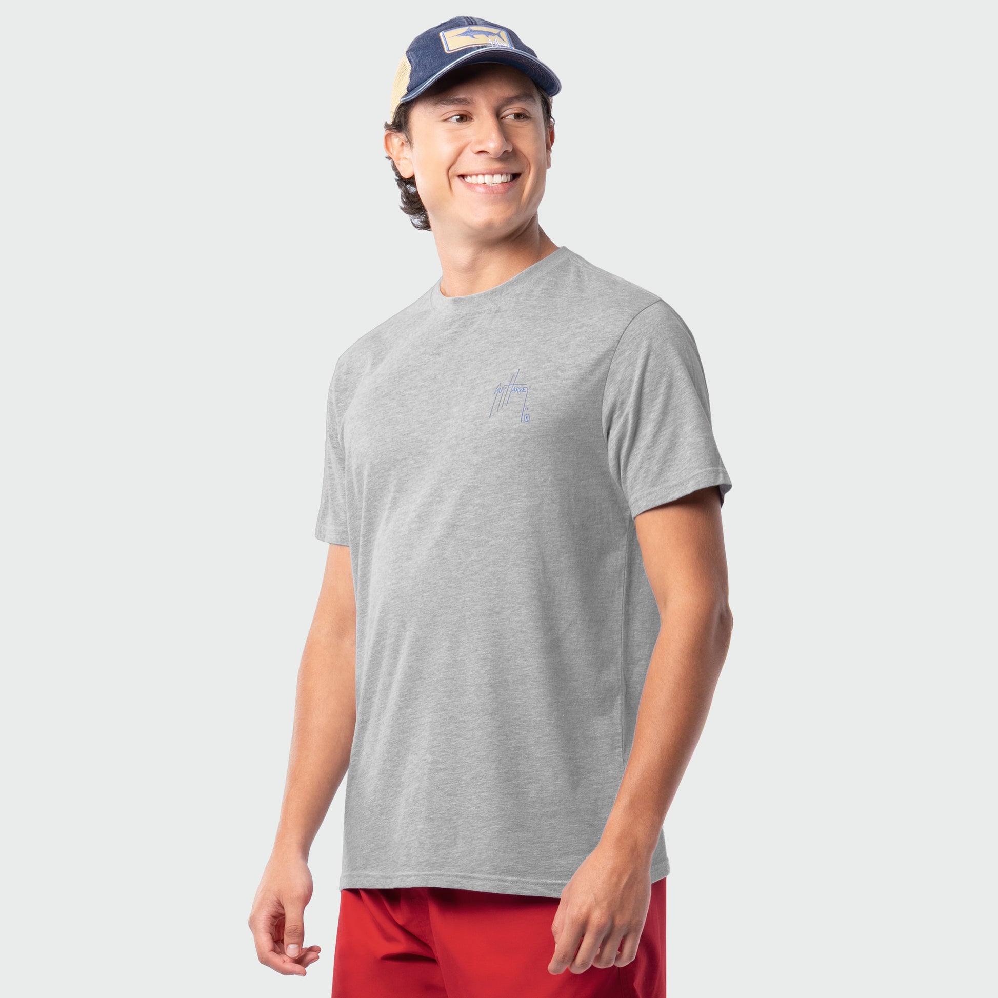 Man wearing a gray t-shirt and red shorts with a white background