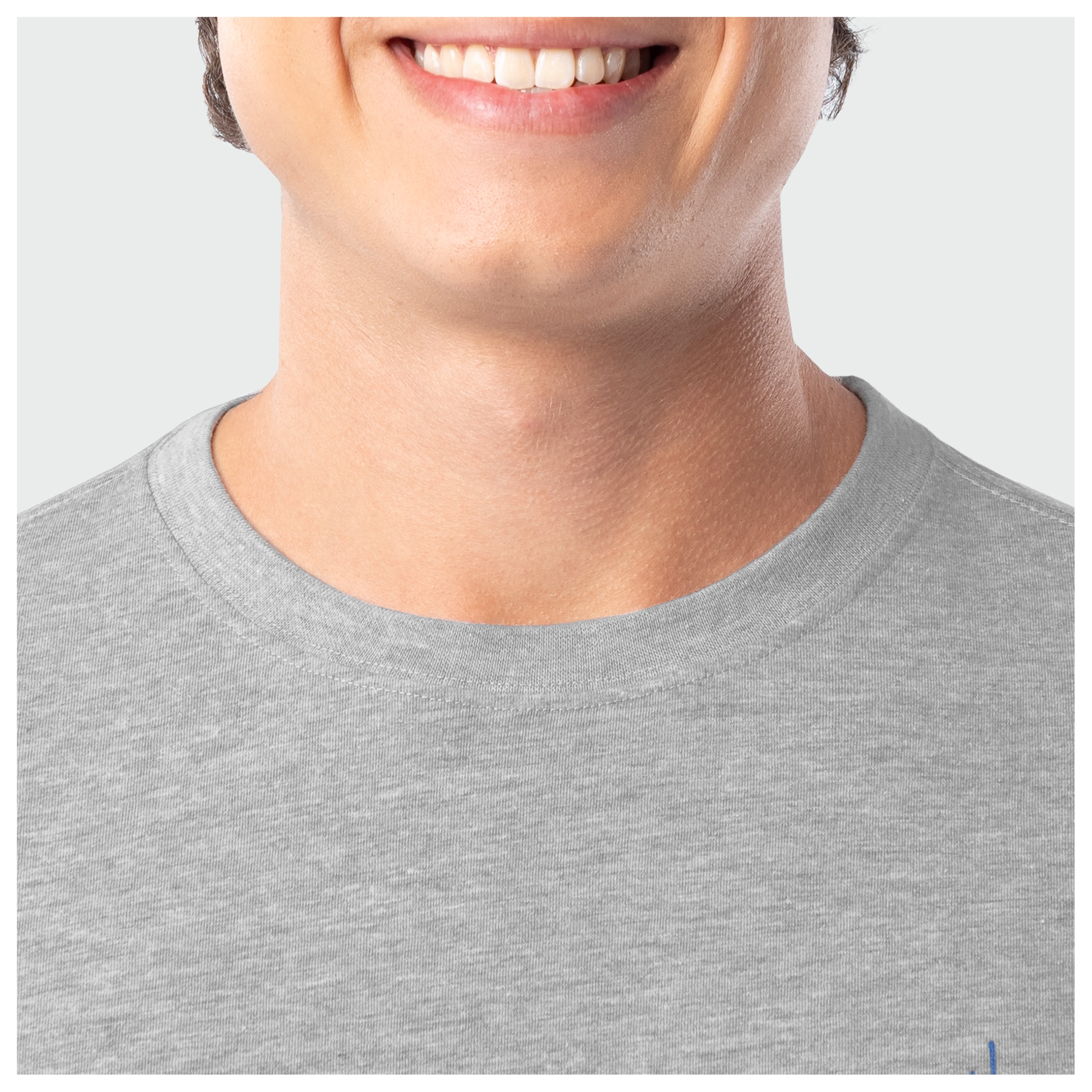 Close-up of a person wearing a gray t-shirt with a visible brand logo.