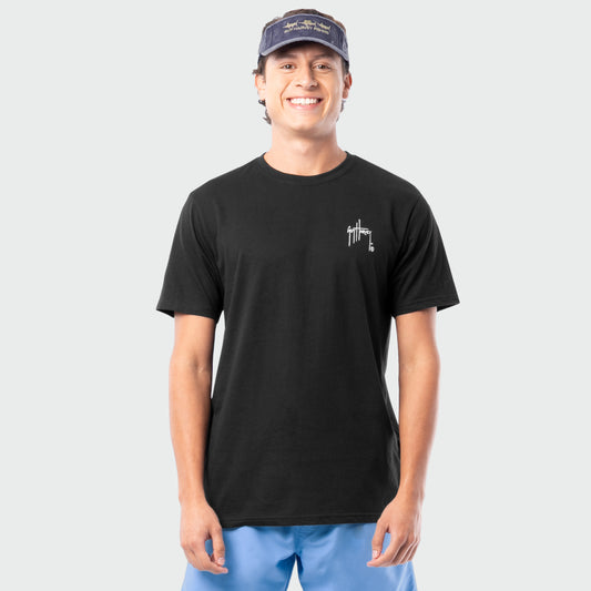 Man wearing a black t-shirt with a white Guy Harvey logo and blue shorts on a white background