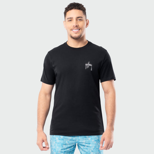 Man wearing a black t-shirt with a Guy Harvey logo on a plain background