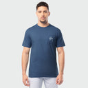 Man wearing a blue t-shirt with a logo on a light gray background