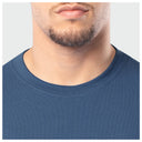 Close-up of a person wearing a blue shirt with a plain background