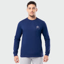 Man wearing a navy blue long-sleeve shirt with a logo on a light gray background