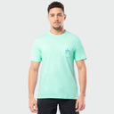 Man wearing a light green t-shirt with a small Guy Harvey logo on a plain background