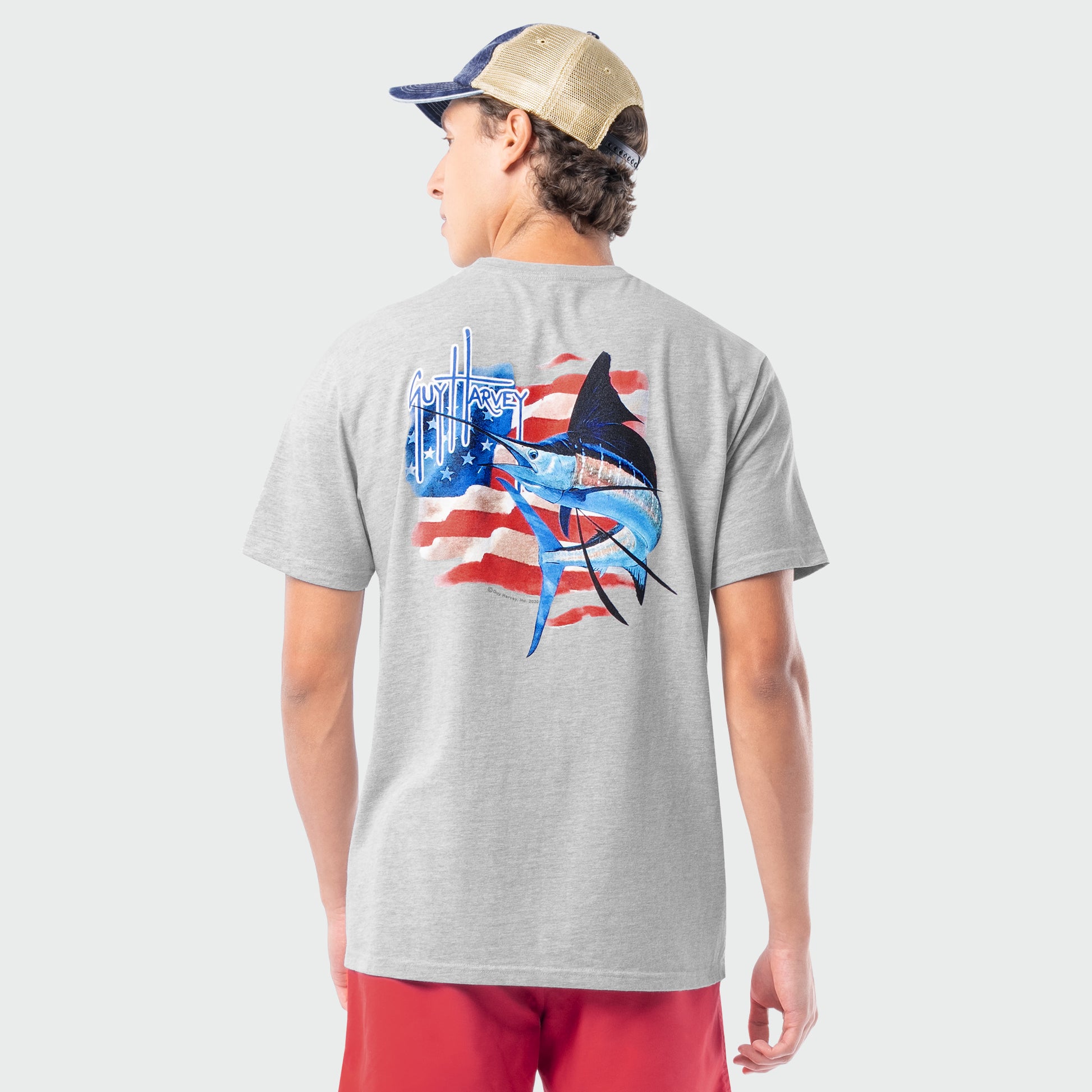 Person wearing a gray t-shirt with a marlin graphic design on the back, standing against a plain background.