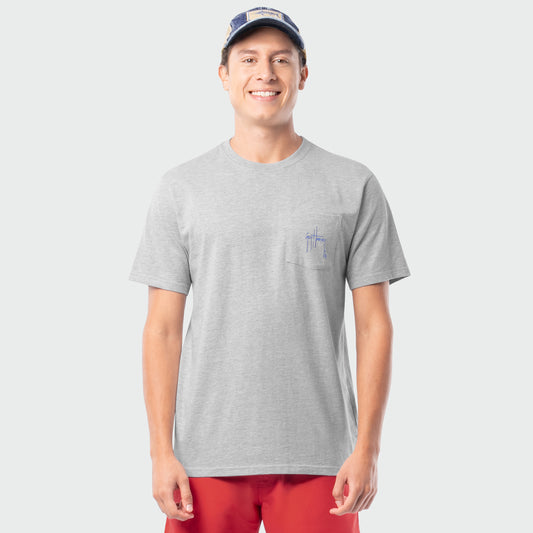 Man wearing a gray t-shirt with a small Guy Harvey logo on a plain background