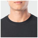 Close-up of a person wearing a black shirt with a plain background