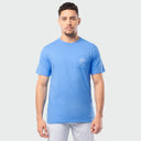 Man wearing a blue pocket t-shirt with a small Guy Harvey logo on a light gray background