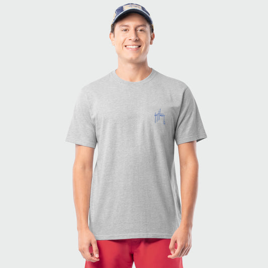 Man wearing a gray t-shirt with a Guy Harvey logo and red shorts on a light gray background