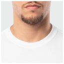 Close-up of a person wearing a white t-shirt with a neutral background