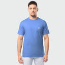Man wearing a blue t-shirt with a small Guy Harvey logo on a light gray background