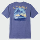 A flat lay image of a blue Guy Harvey threadcycle tee featuring a jumping marlin and a boat on the back.