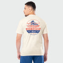 Man wearing a Guy Harvey t-shirt with a volcano graphic on a plain background