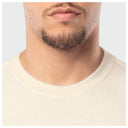 Close-up of a person wearing a beige shirt with a neutral background