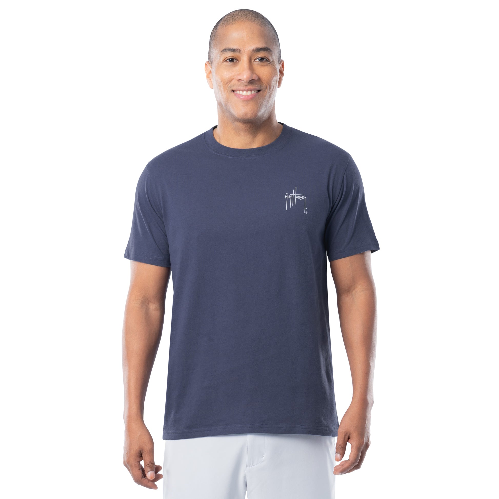 Man wearing a navy blue t-shirt with a Guy Harvey logo on a white background