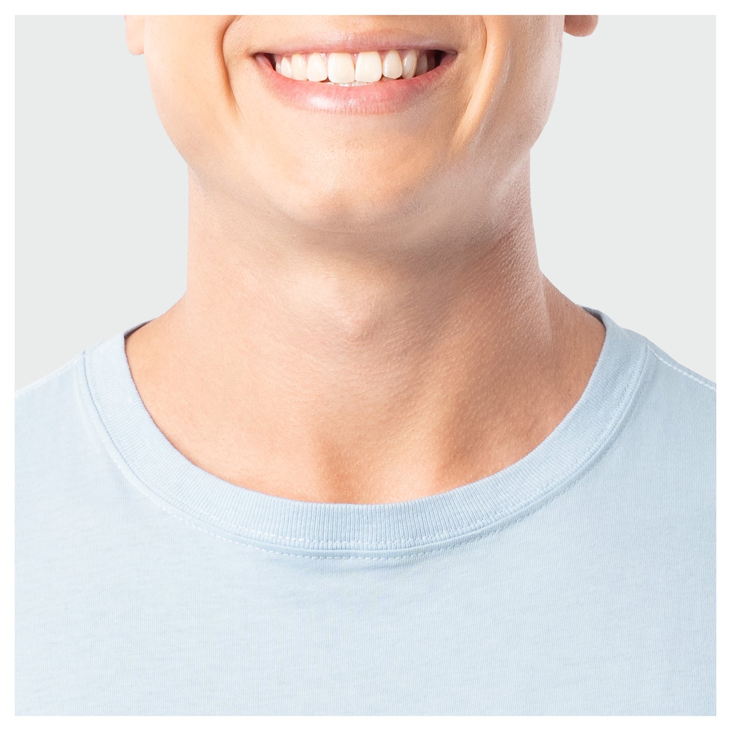 Close-up of a person wearing a light blue shirt with a plain background