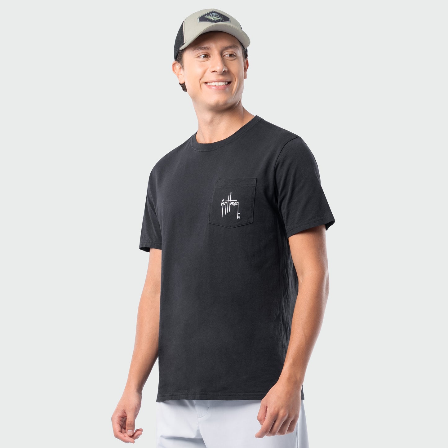 Man wearing a black t-shirt with a logo on a plain background