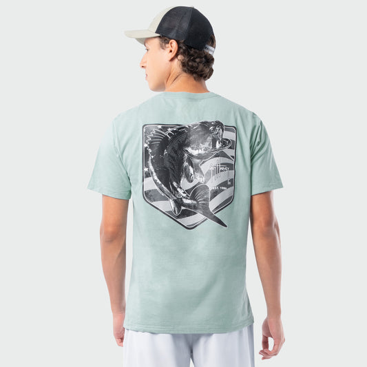 Person wearing a light green t-shirt with a bass fish graphic on the back, standing against a white background.