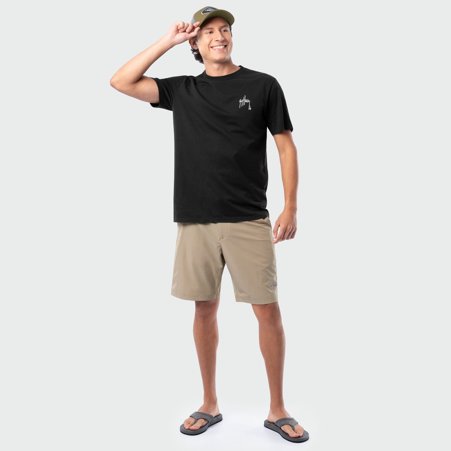 Man wearing a black t-shirt and beige shorts on a white background