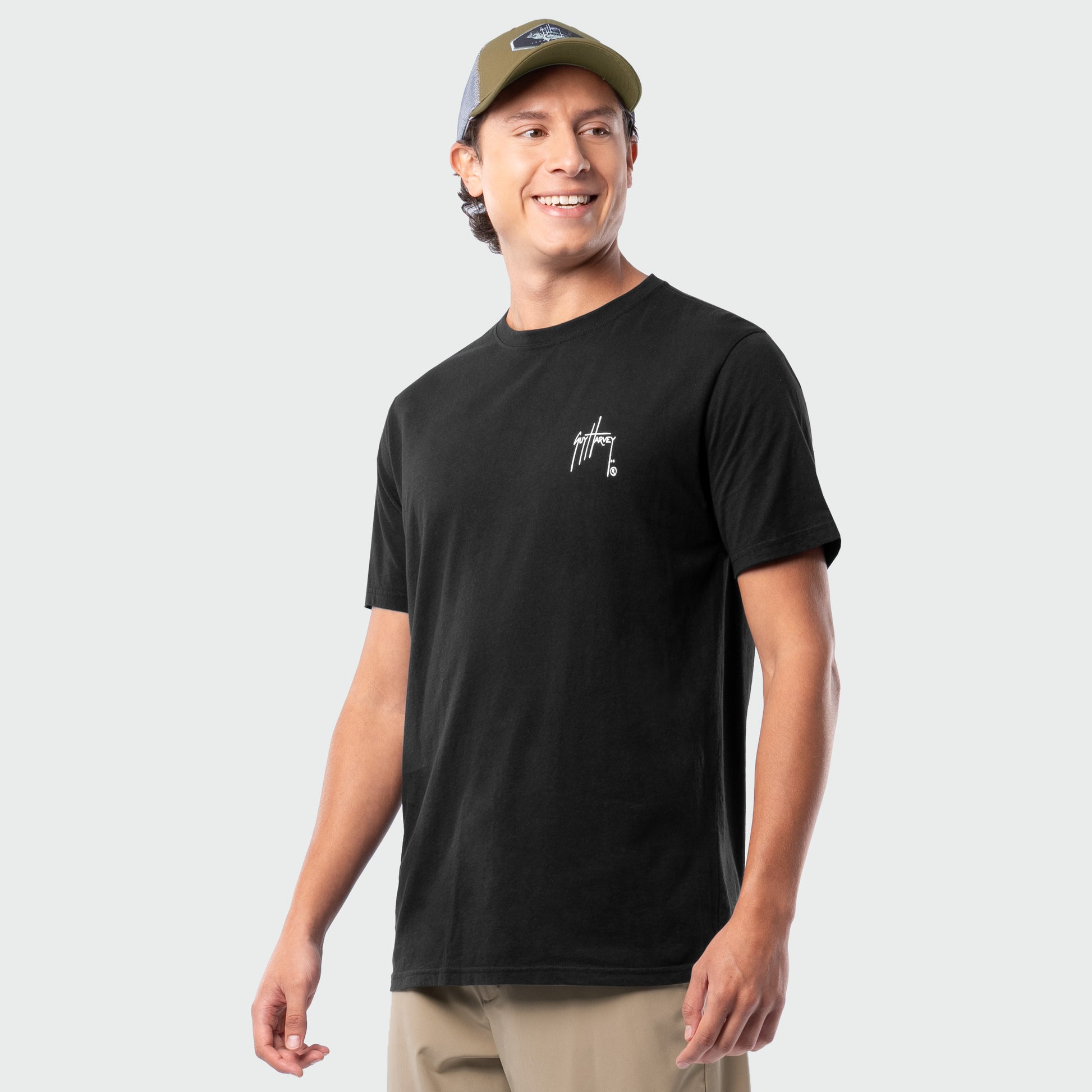 Man wearing a black t-shirt with a logo on a light gray background