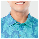 Close-up on the neck collar of a person wearing a blue tropical pattern shirt with a white background