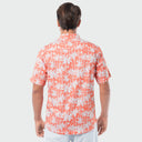 Man wearing a patterned shirt with white palm trees on a light gray background