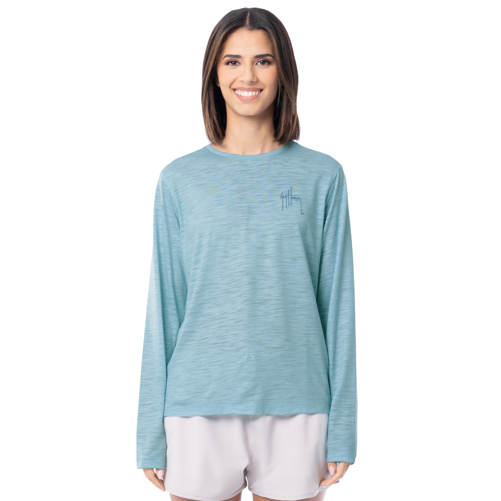 Woman wearing a light blue long-sleeve shirt with a small logo on a white background