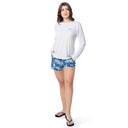 Woman wearing a white long-sleeve shirt and blue floral shorts on a white background