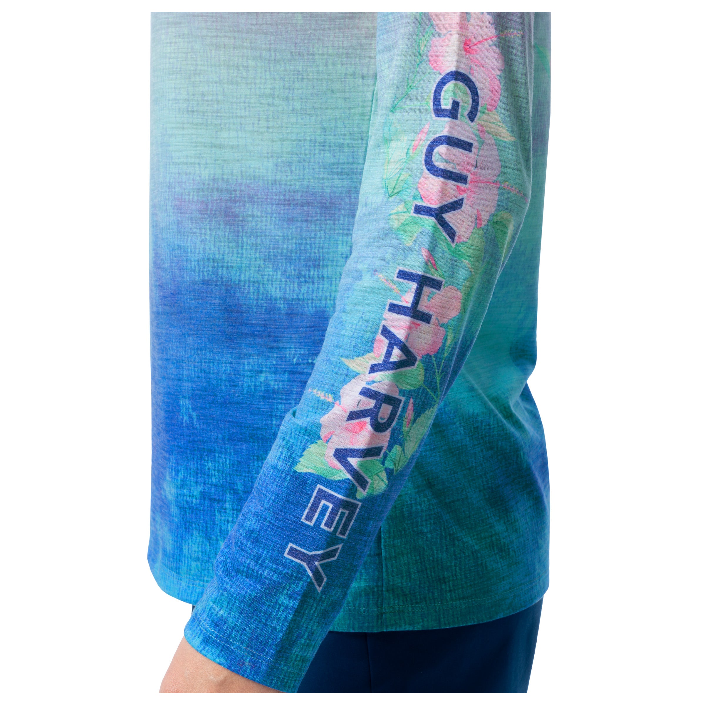 Close-up of a sleeve with floral design and 'Guy Harvey' branding on a blue background