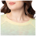 Close-up of a person wearing a light green top with a blurred background