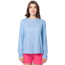 Woman wearing a light blue long-sleeve shirt and pink shorts on a white background