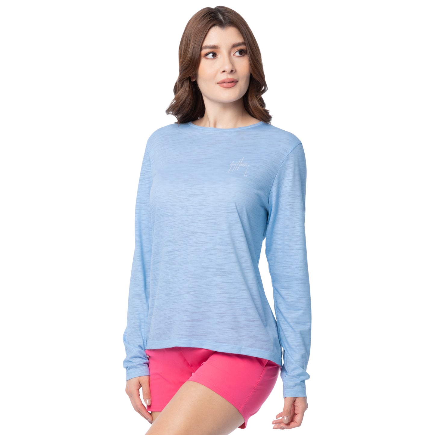 Woman wearing a light blue long-sleeve top and pink shorts on a white background