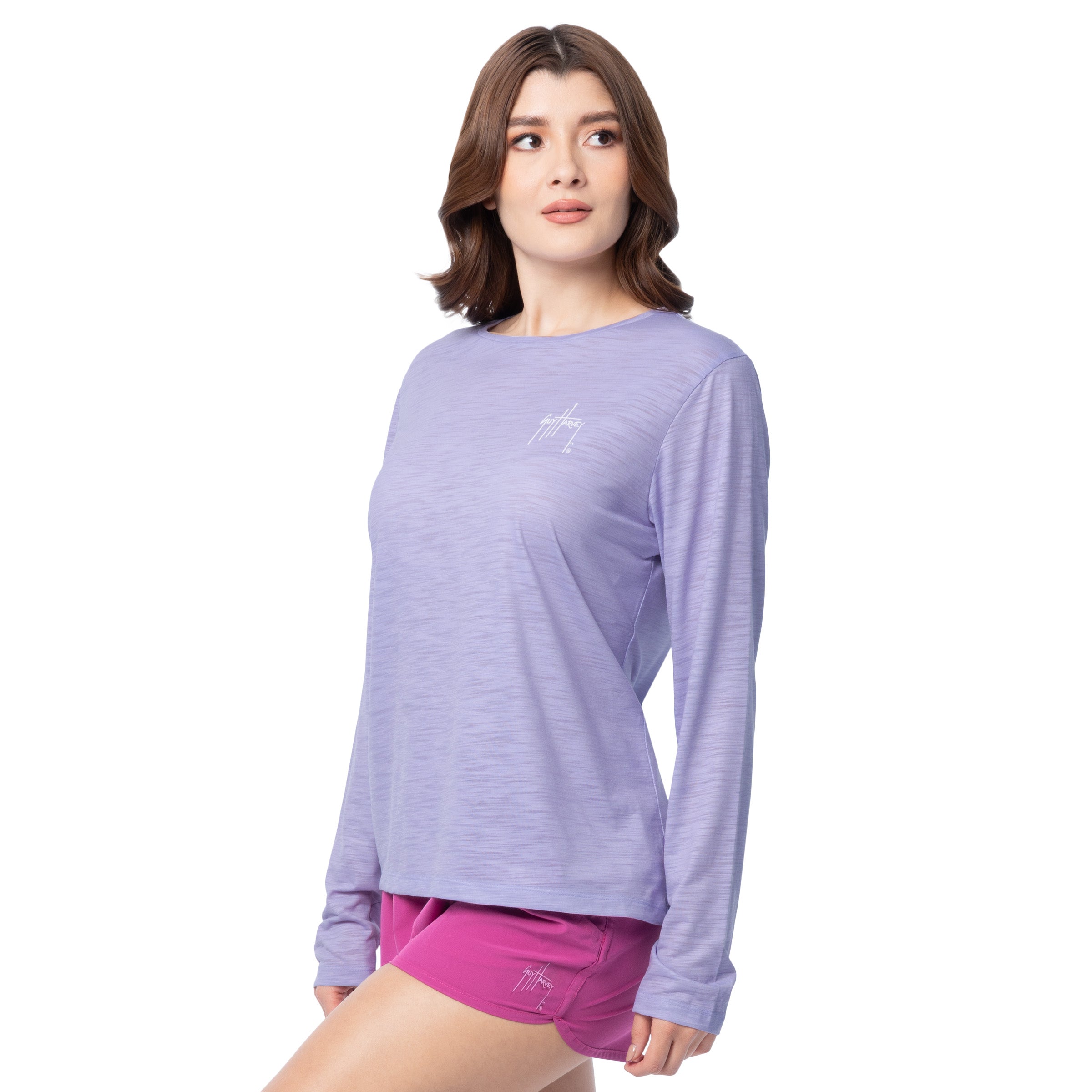Woman wearing a purple long-sleeve shirt and pink shorts on a white background