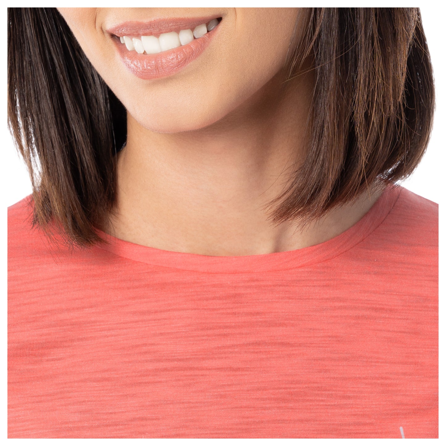 Close-up of a person wearing a coral-colored top with a blurred background