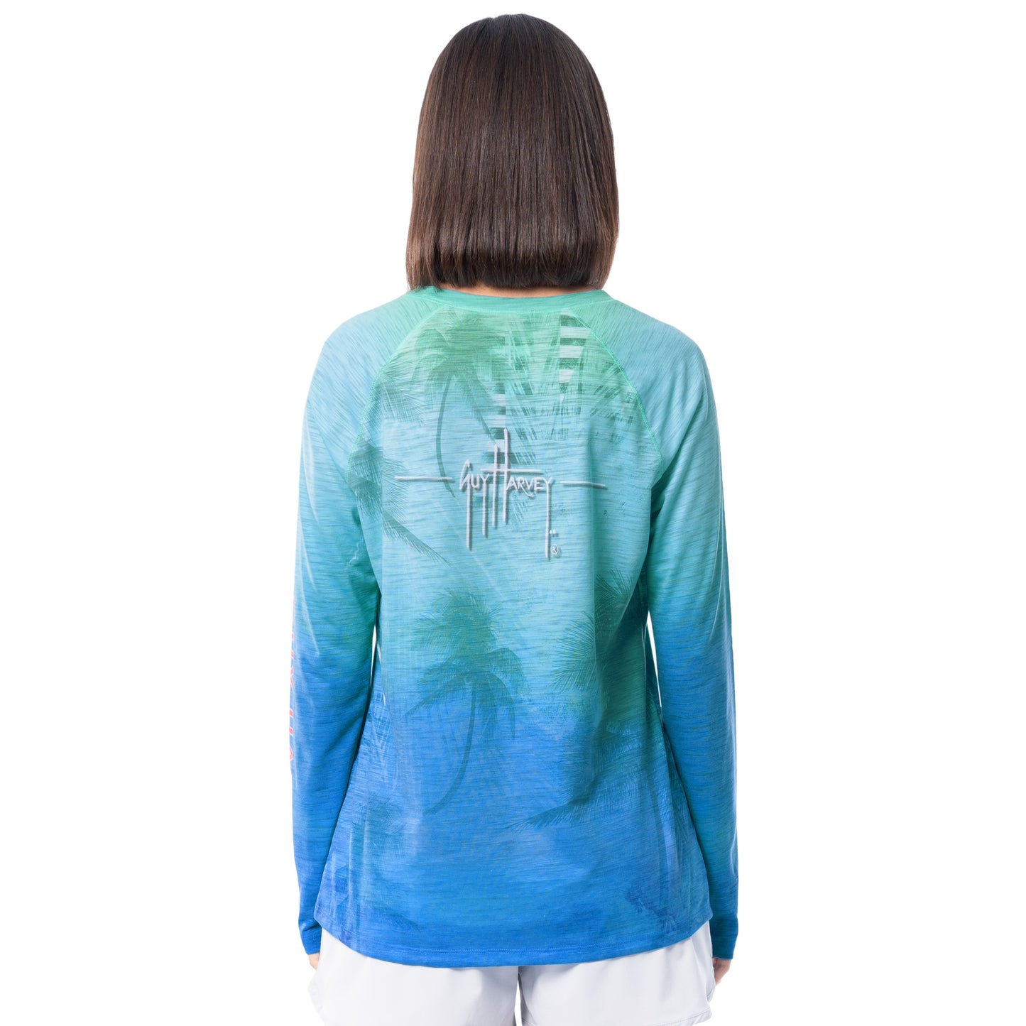 Woman wearing a blue and green tie-dye long-sleeve shirt with a logo on the back against a white background