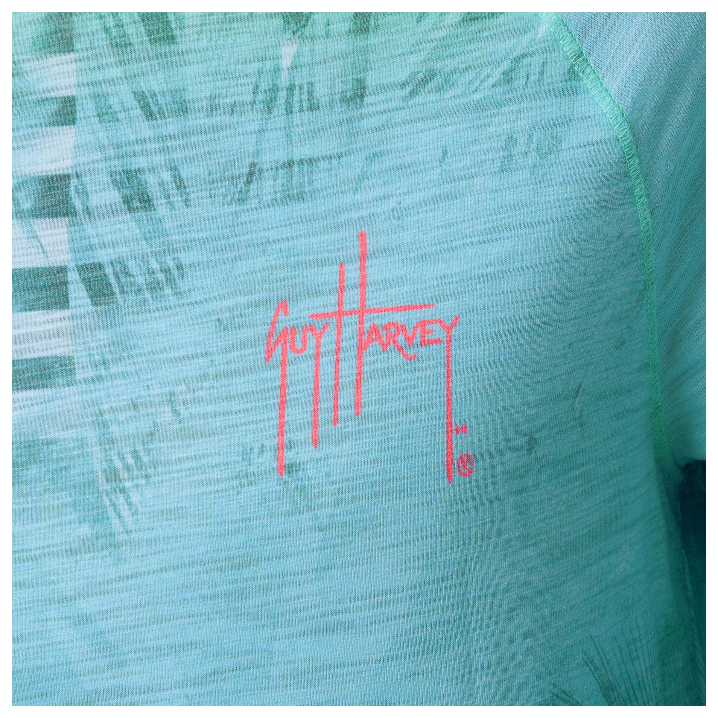 Close-up of a Guy Harvey logo on a textured green surface