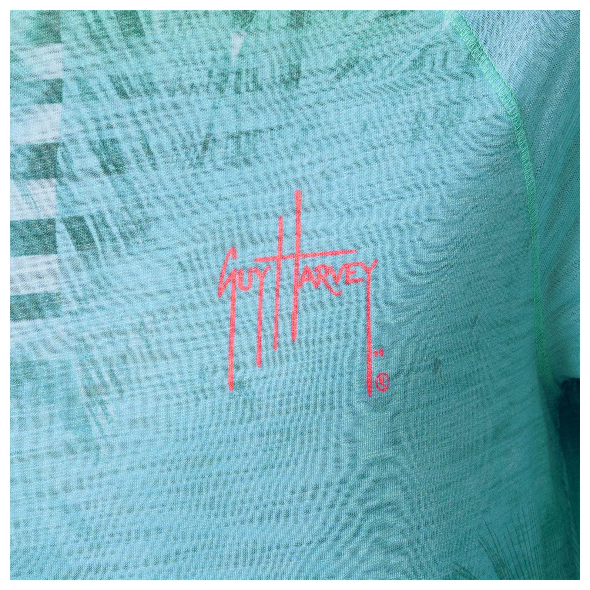 Close-up of a Guy Harvey logo on a textured green surface